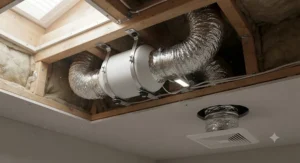 A compact 4-inch inline booster fan for bathroom exhaust mounted neatly inside a confined ceiling joist bay.